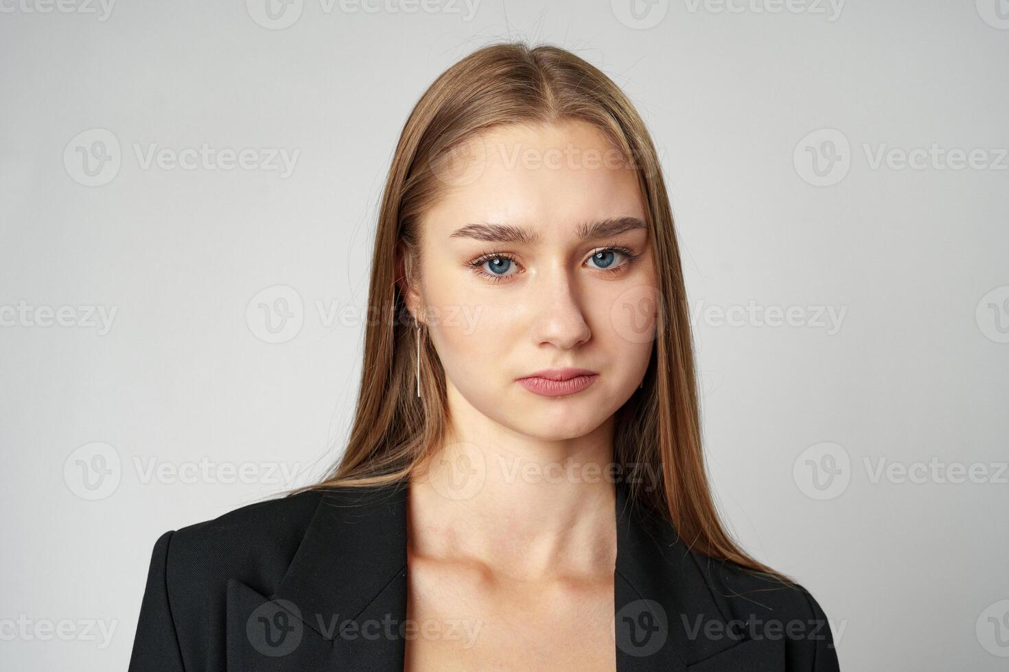 Young Woman in Black Jacket Posing to Camera against gray background photo