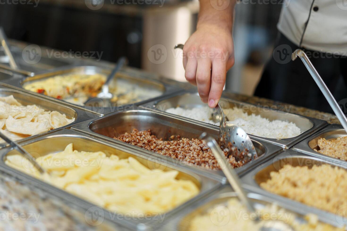 Chef Serving Freshly Cooked Dishes at a Restaurant Buffet During Lunchtime photo