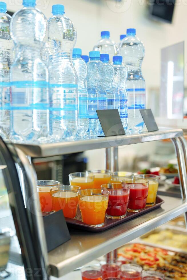 Colorful Array of Fruit Juice Cups on a Serving Cart in a Cafeteria photo