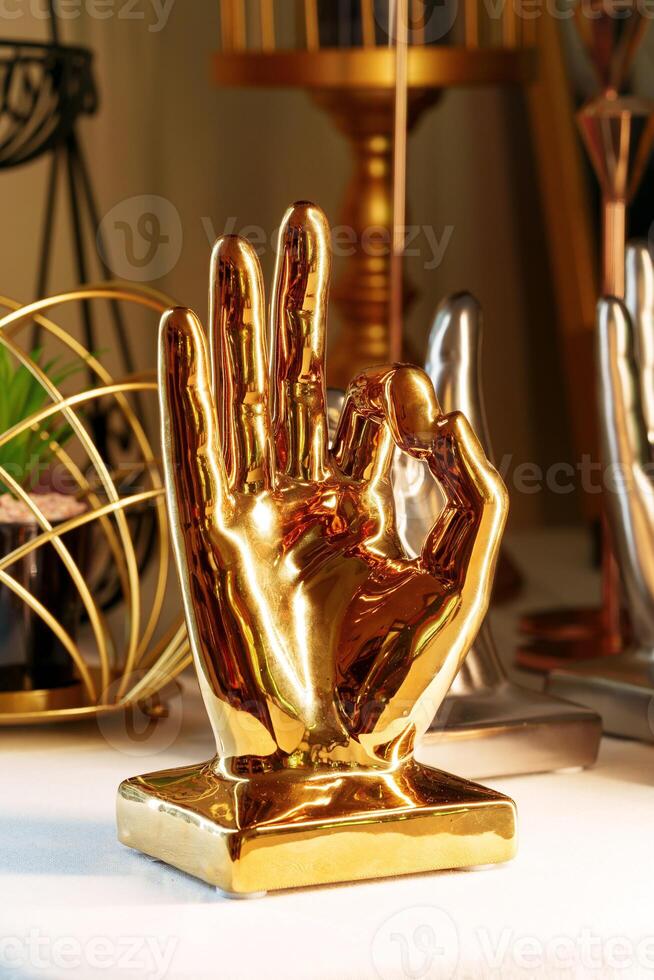 Golden Hand Sculpture on Display in a Cozy Indoor Setting at Dusk photo