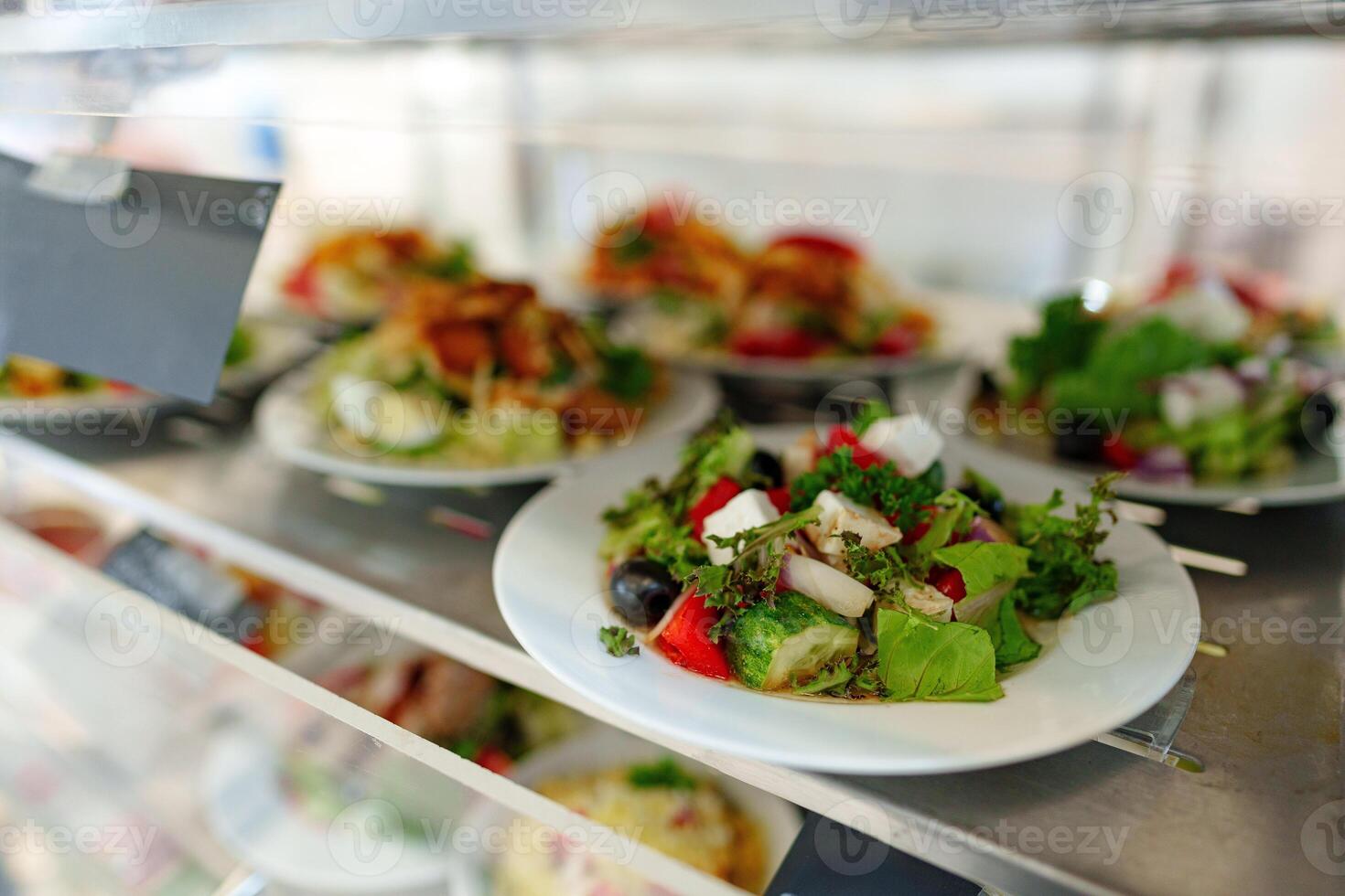 Freshly Prepared Salads on Display in a Cafeteria During Lunchtime photo