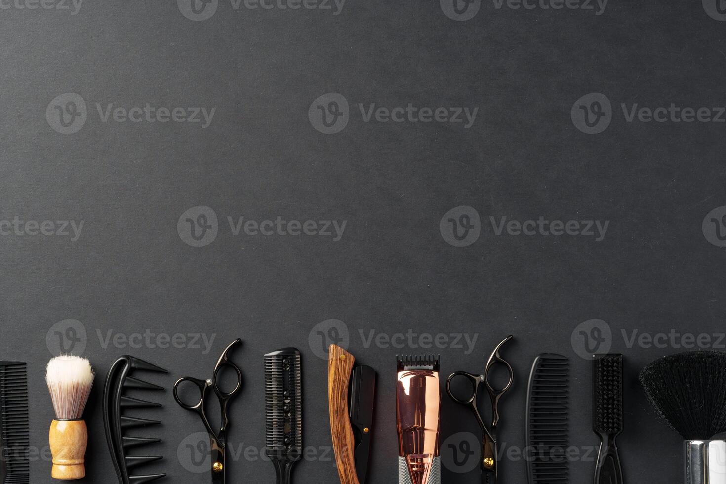 An Assortment of Professional Hairdressing Tools Laid Out on a Dark Surface photo