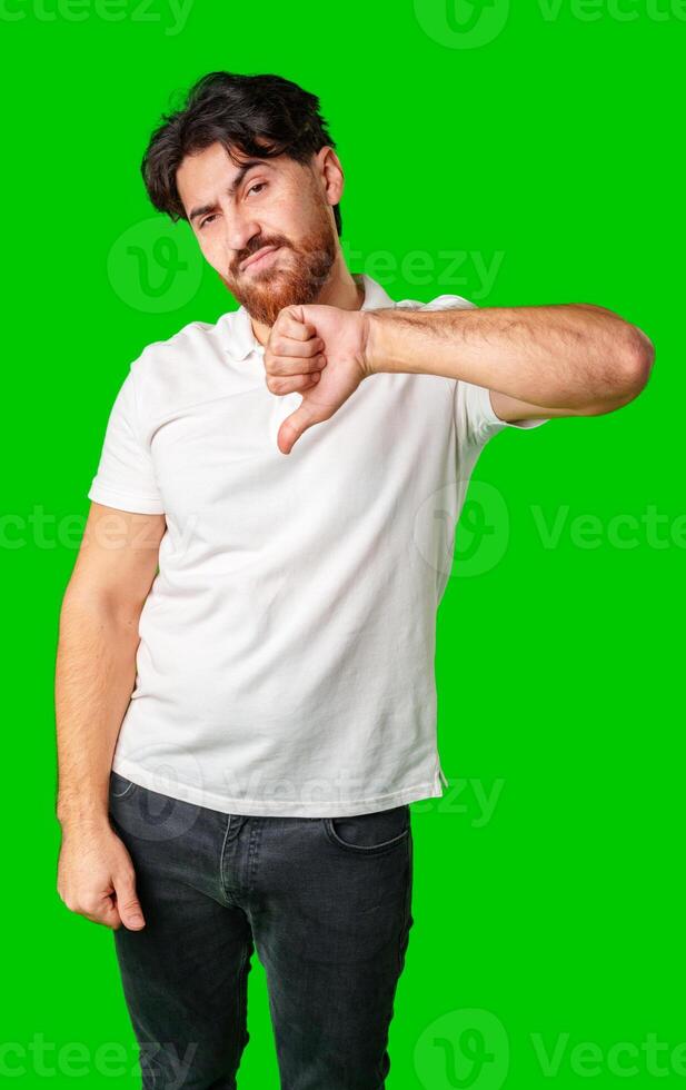 A man expresses disappointment with a thumbs down gesture against a bright green background photo