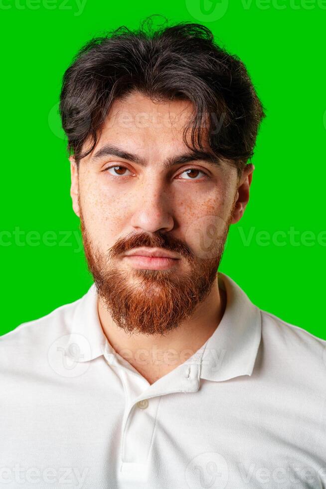 A man with a serious expression stands against a vibrant green background photo