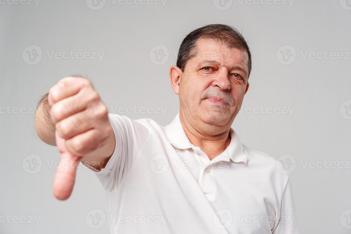 A middle-aged man expressing disapproval with a thumbs-down gesture i photo