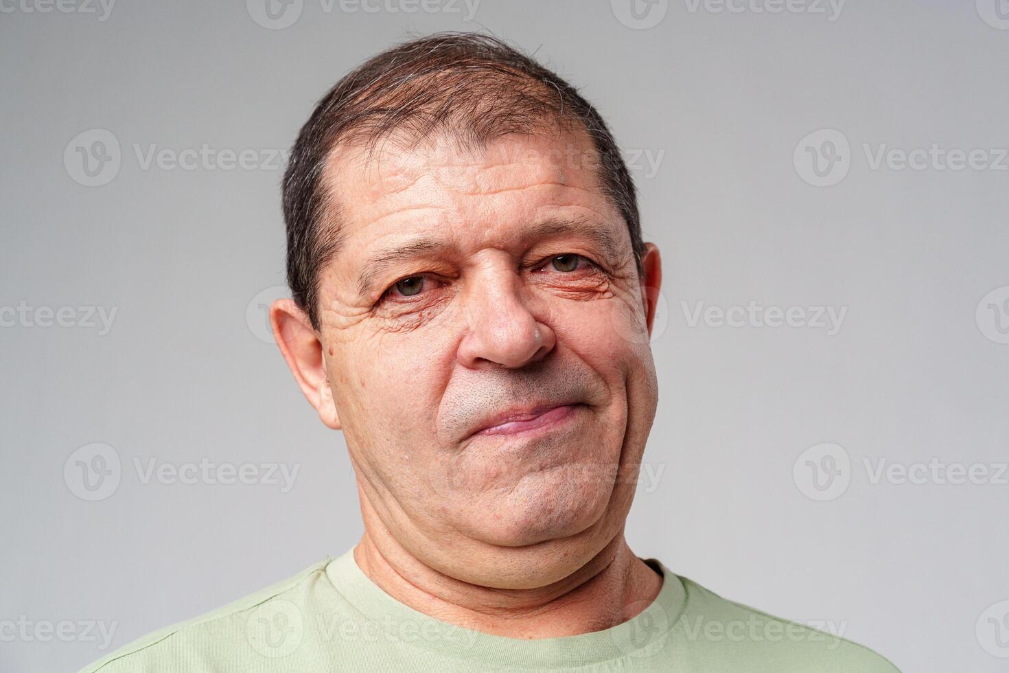 Middle-aged man with a thoughtful expression against a plain background photo