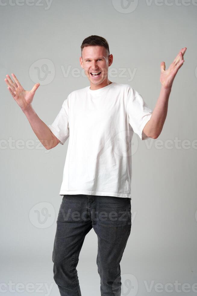 Portrait of surprised young man with shocked facial expression against gray background photo