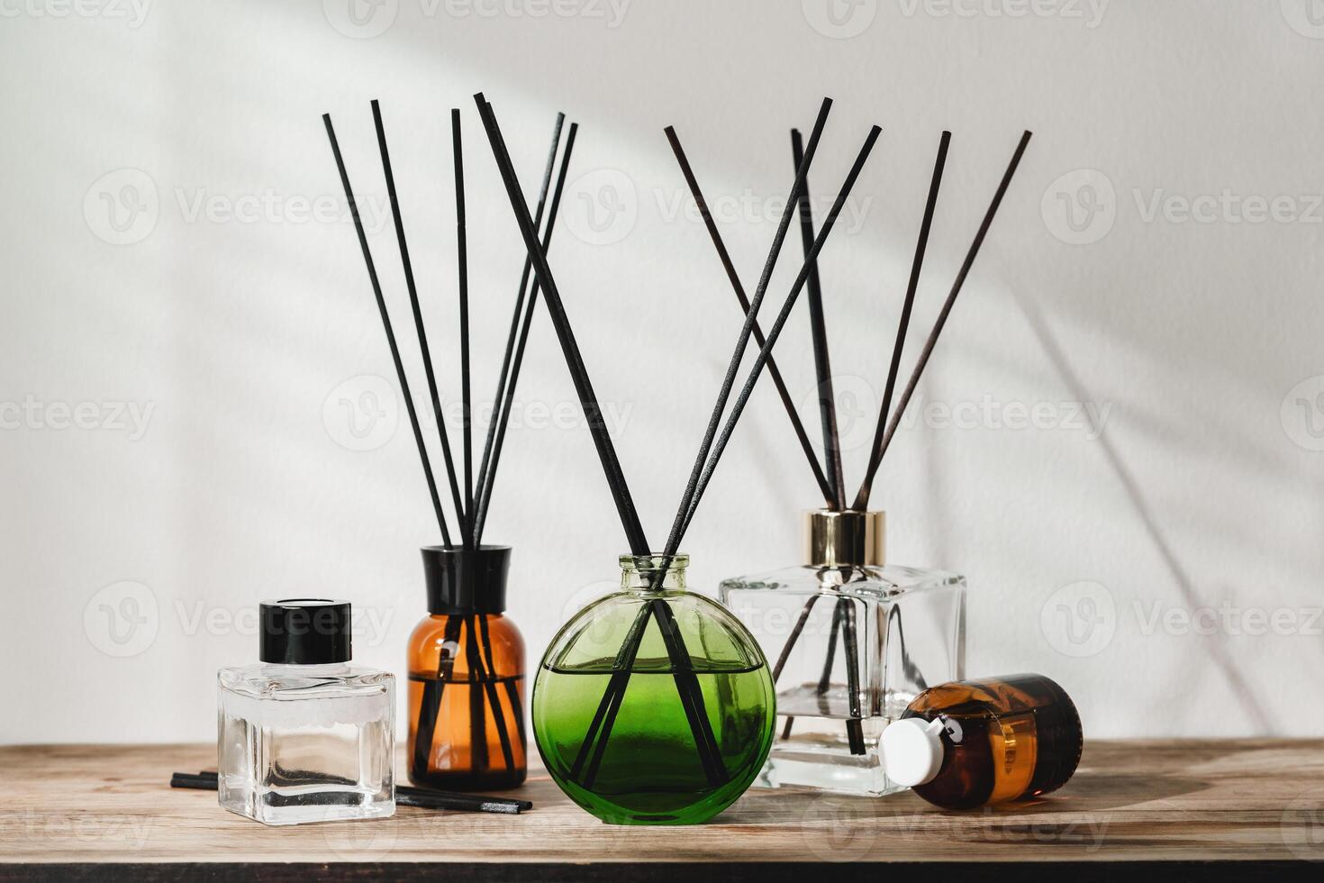 A Collection of Aromatic Reed Diffusers on a Wooden Table Against a Neutral Background photo