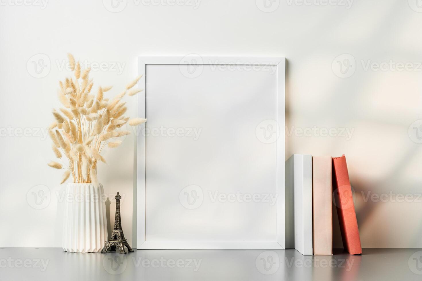Blank picture frame and dried flower in a vase on white background photo