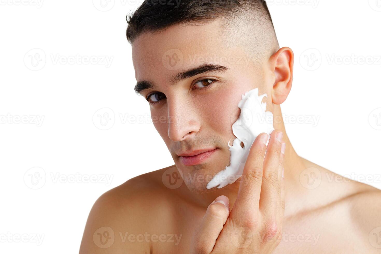 Young handsome man applying shaving foam against white background photo