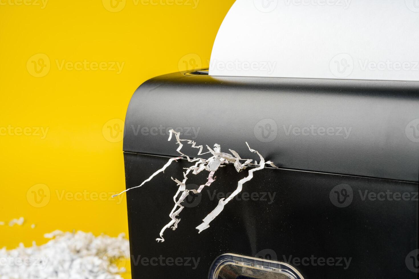 Office paper shredder on yellow studio background photo
