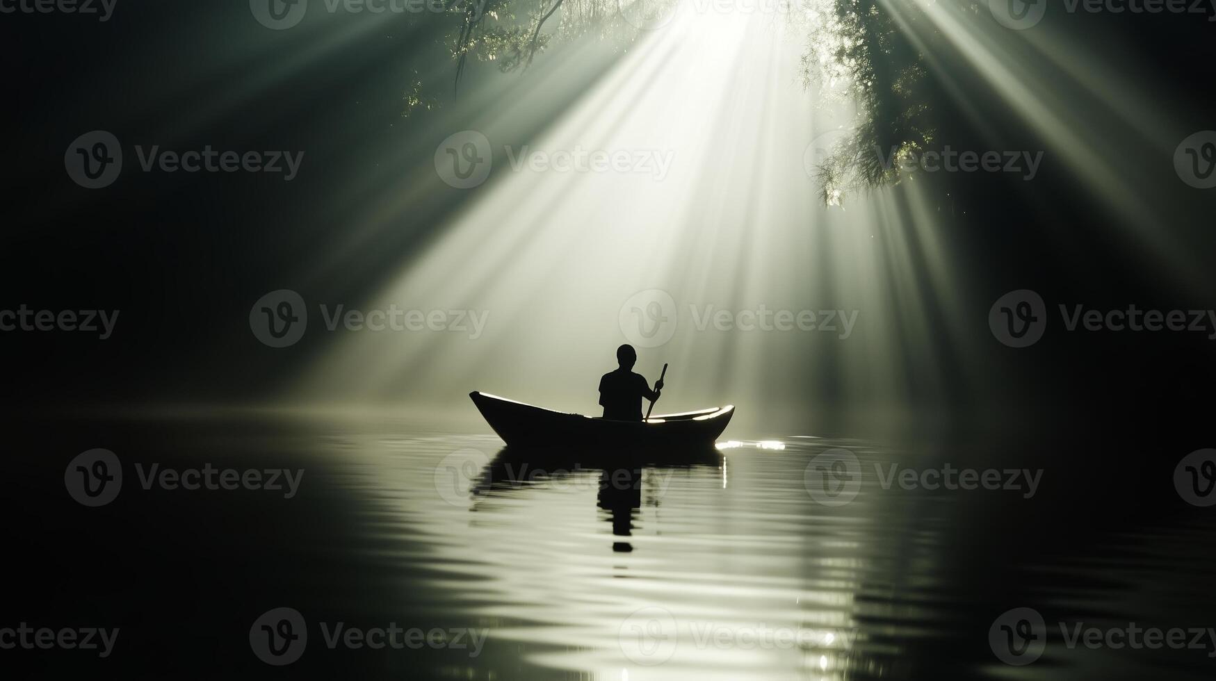 A lone canoeist paddles silently through misty waters at dawn, as sunlight filters through the trees photo