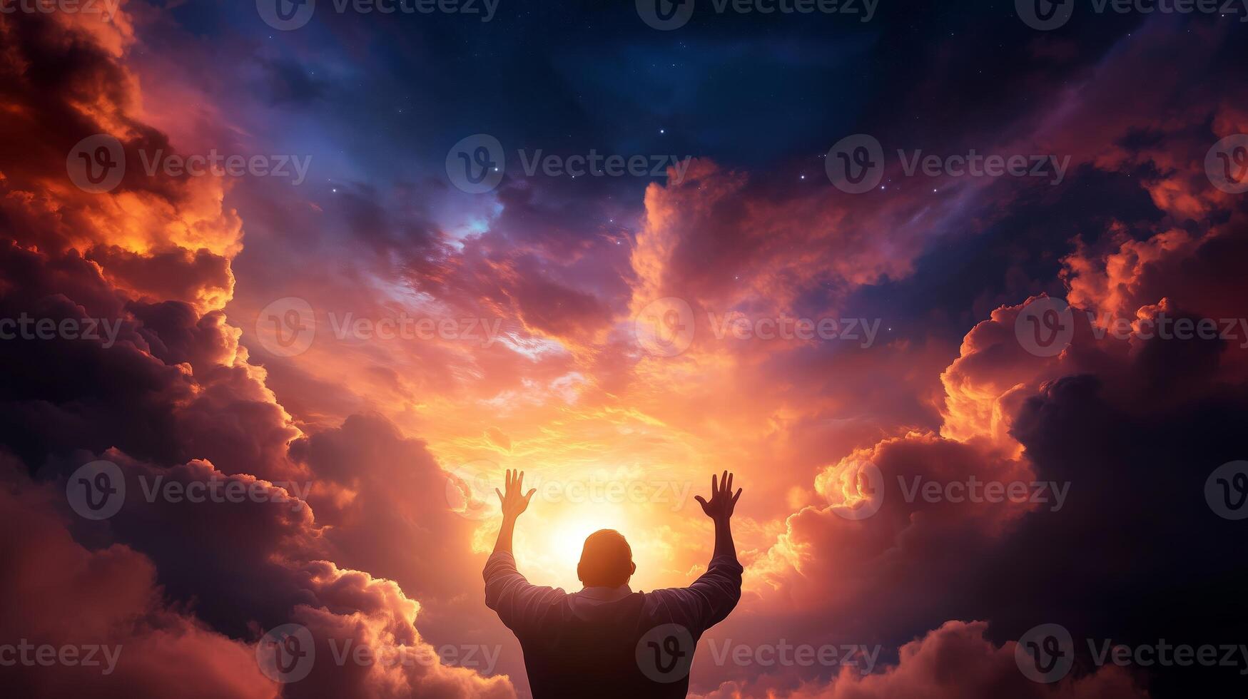 A person standing against a dramatic sky at sunset with arms raised, expressing emotions in a moment of significance photo