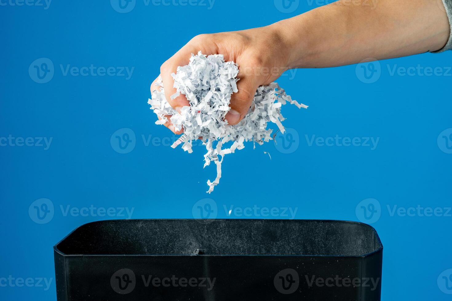 Male hand holding a bunch of shredded paper photo