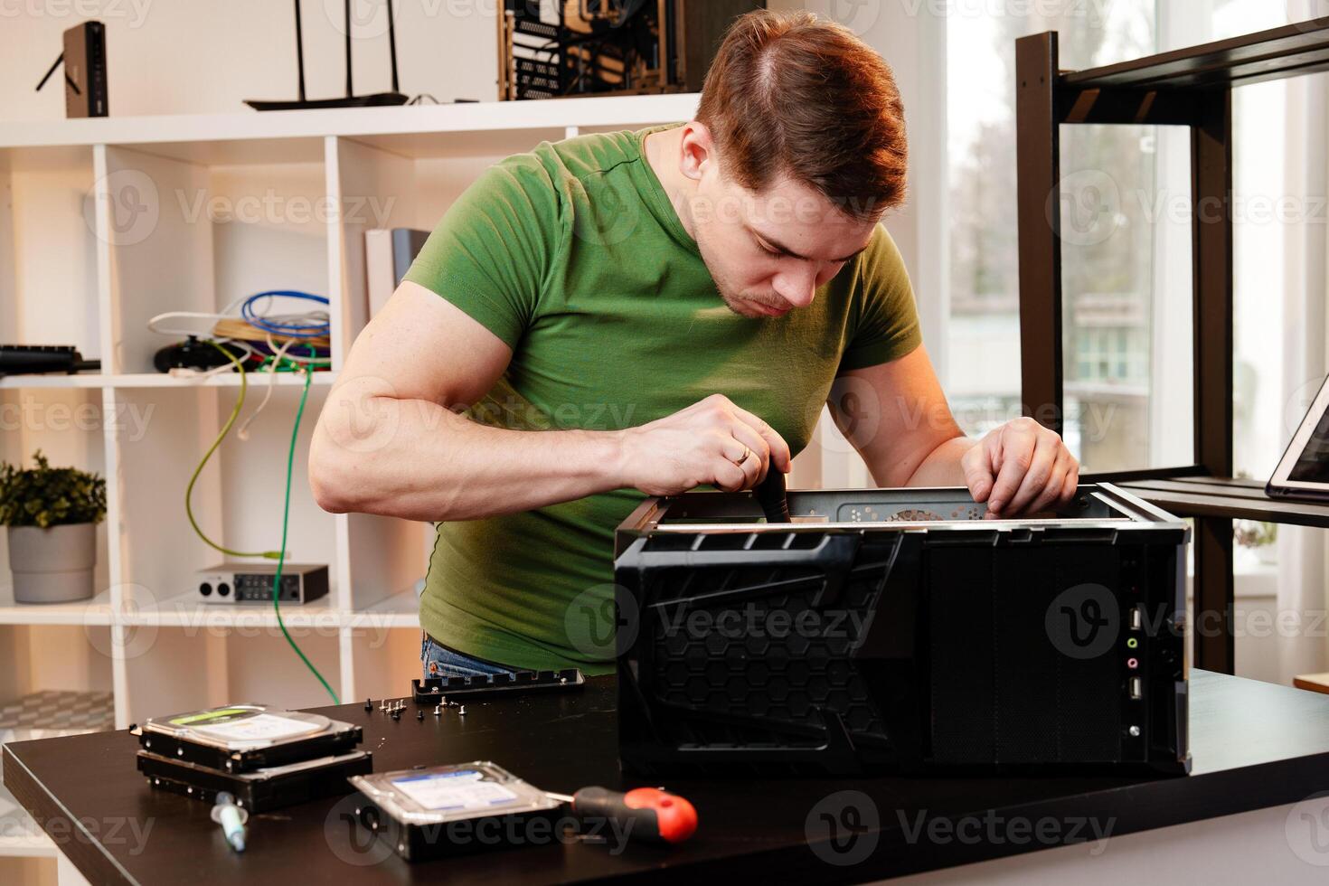 Man assembles a computer system unit at home photo