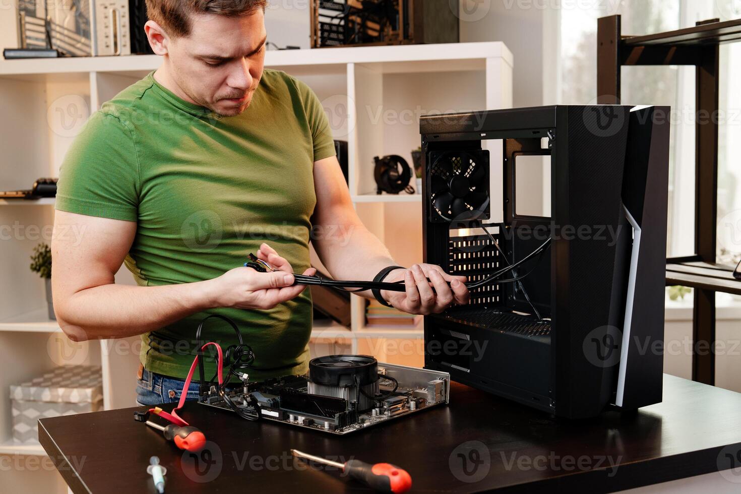 Man assembles a computer system unit at home photo