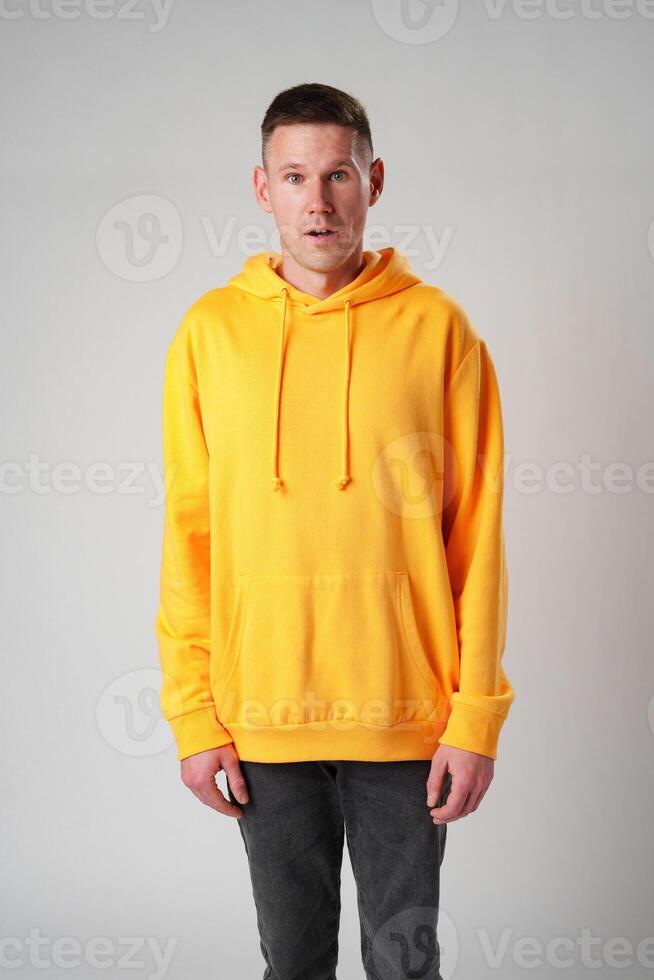 Portrait of surprised young man with shocked facial expression against gray background photo