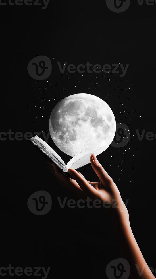 A hand holding an open book releases a large full moon under a starry night sky photo