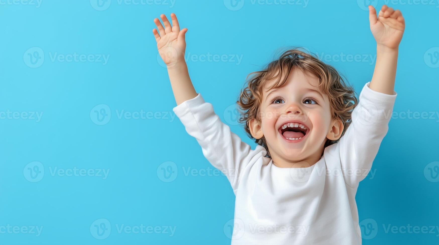 Joyful child playing with excitement against a vibrant blue background during a sunny day at home photo