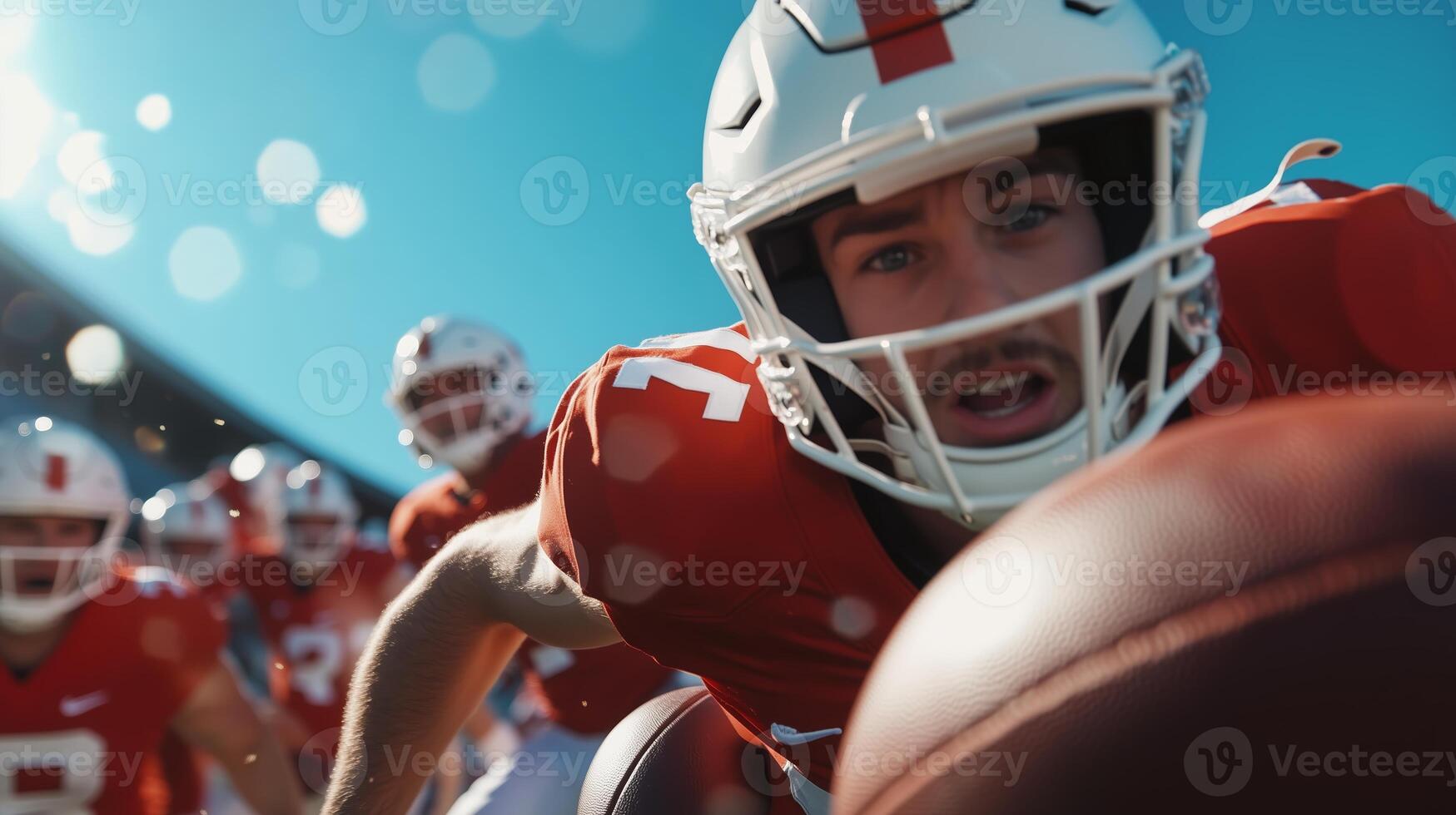 A football player reaches for the ball during a practice session under clear skies at a stadium on a sunny afternoon photo