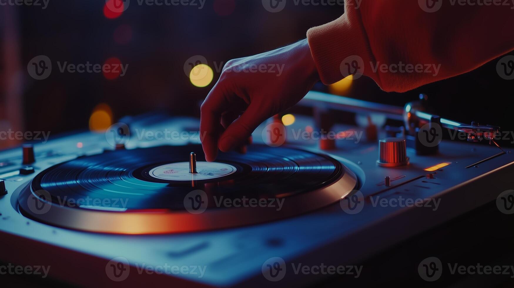 A DJ adjusts the turntable while mixing tracks at a vibrant night event filled with colorful lights and an energetic atmosphere photo