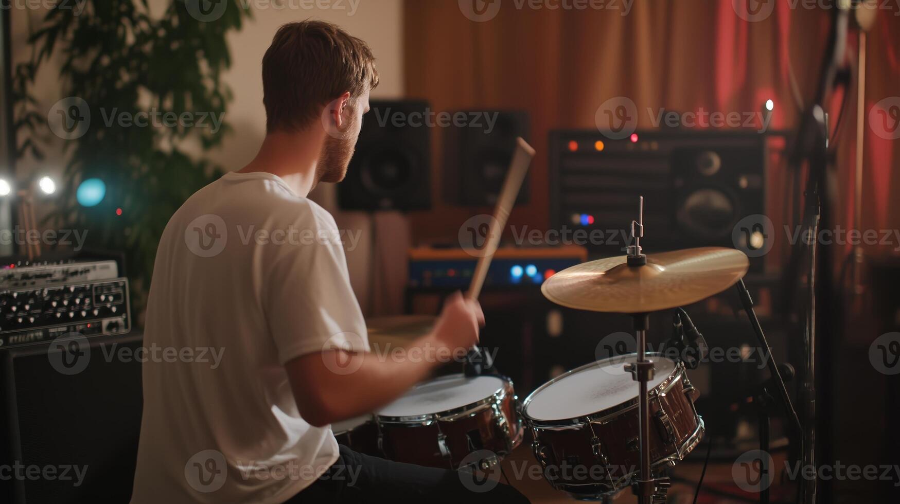 A drummer playing energetically in a cozy recording studio during a late-night jam session photo