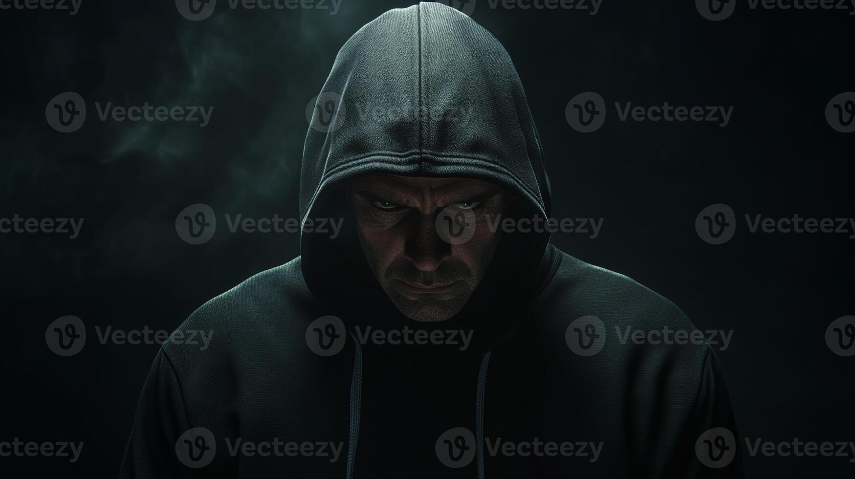 A solitary figure in a dark hoodie stares intently in a dimly lit space, surrounded by a misty atmosphere at night photo