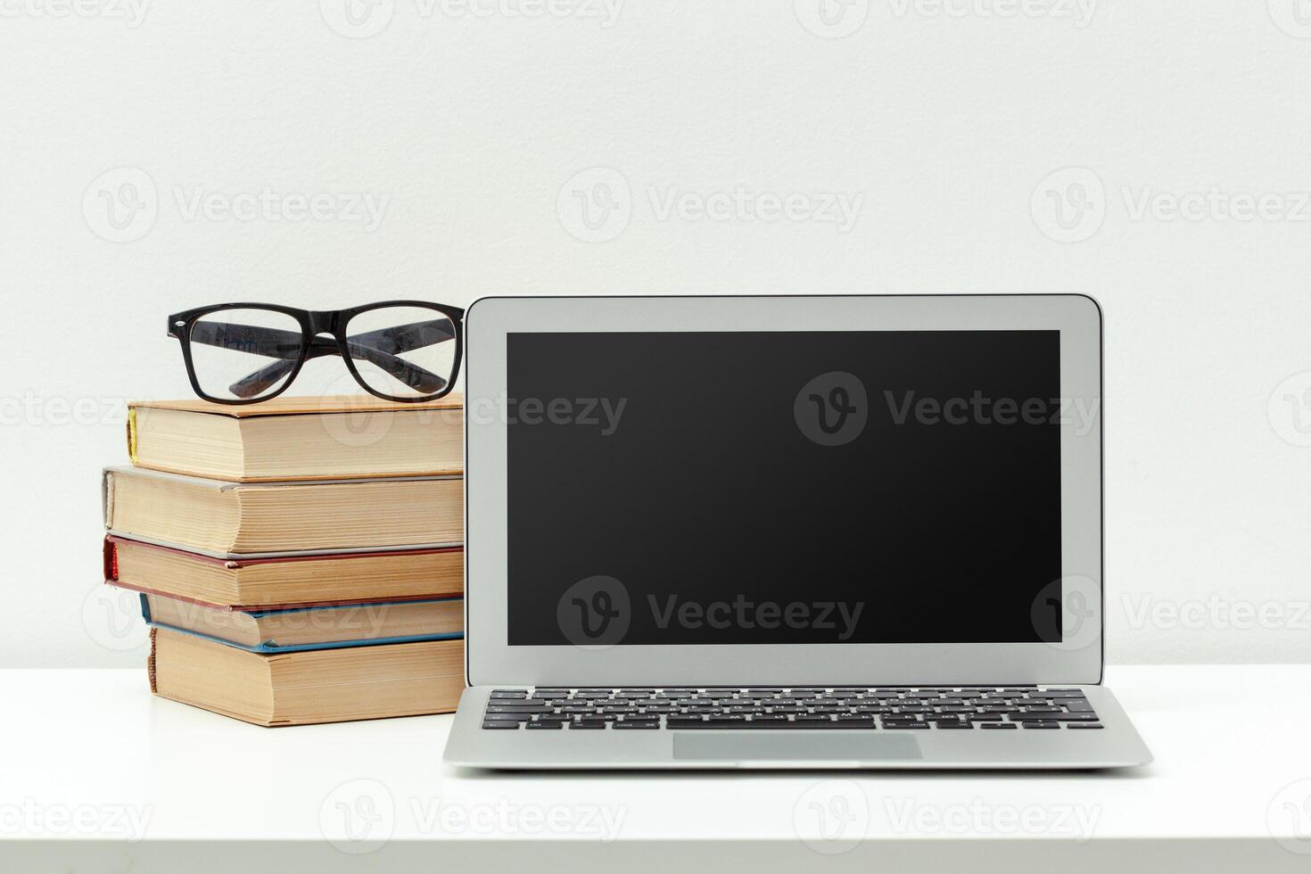 Working desk.Open laptop, books and other office supply photo