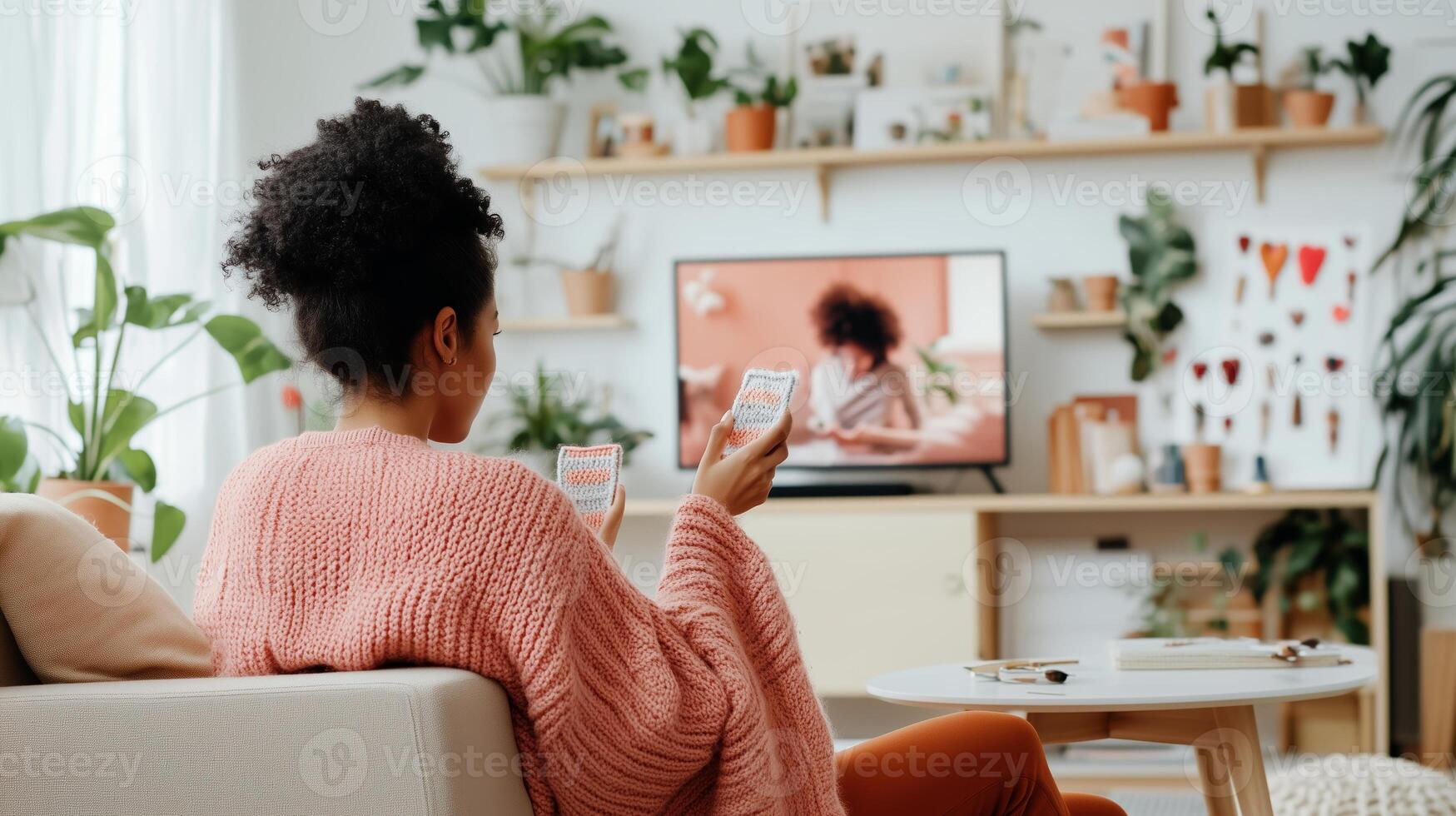 A woman relaxes at home, enjoying a cozy evening with a game and her favorite show playing on the television photo