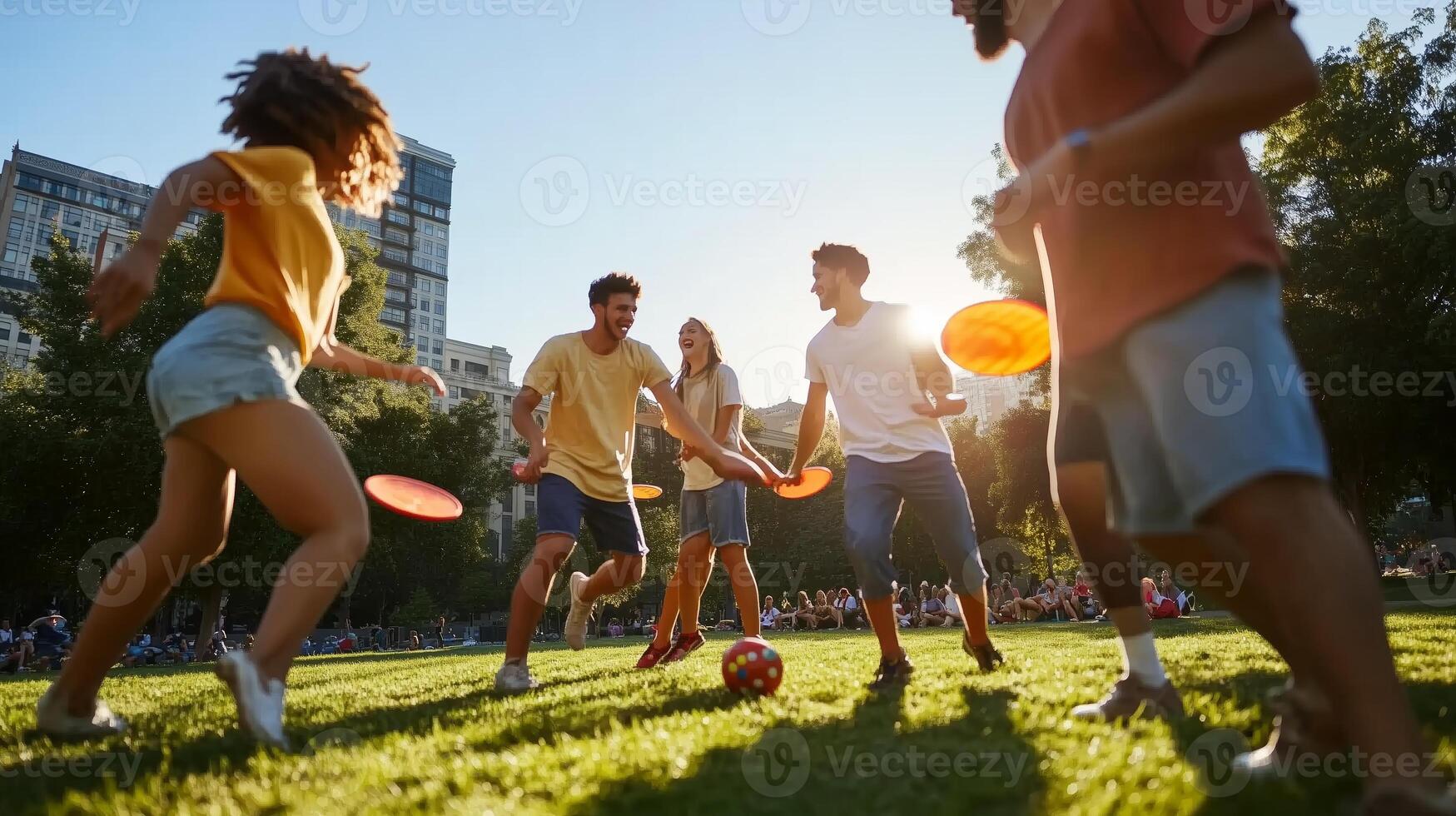 Group of young friends playing frisbee and soccer in a sunlit park during late afternoon in an urban setting photo