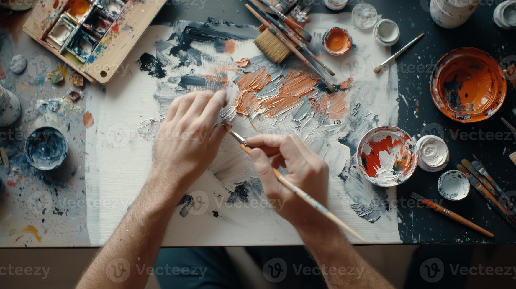 An artist creating a colorful composition in a well-lit studio filled with paint and brushes during a creative afternoon photo