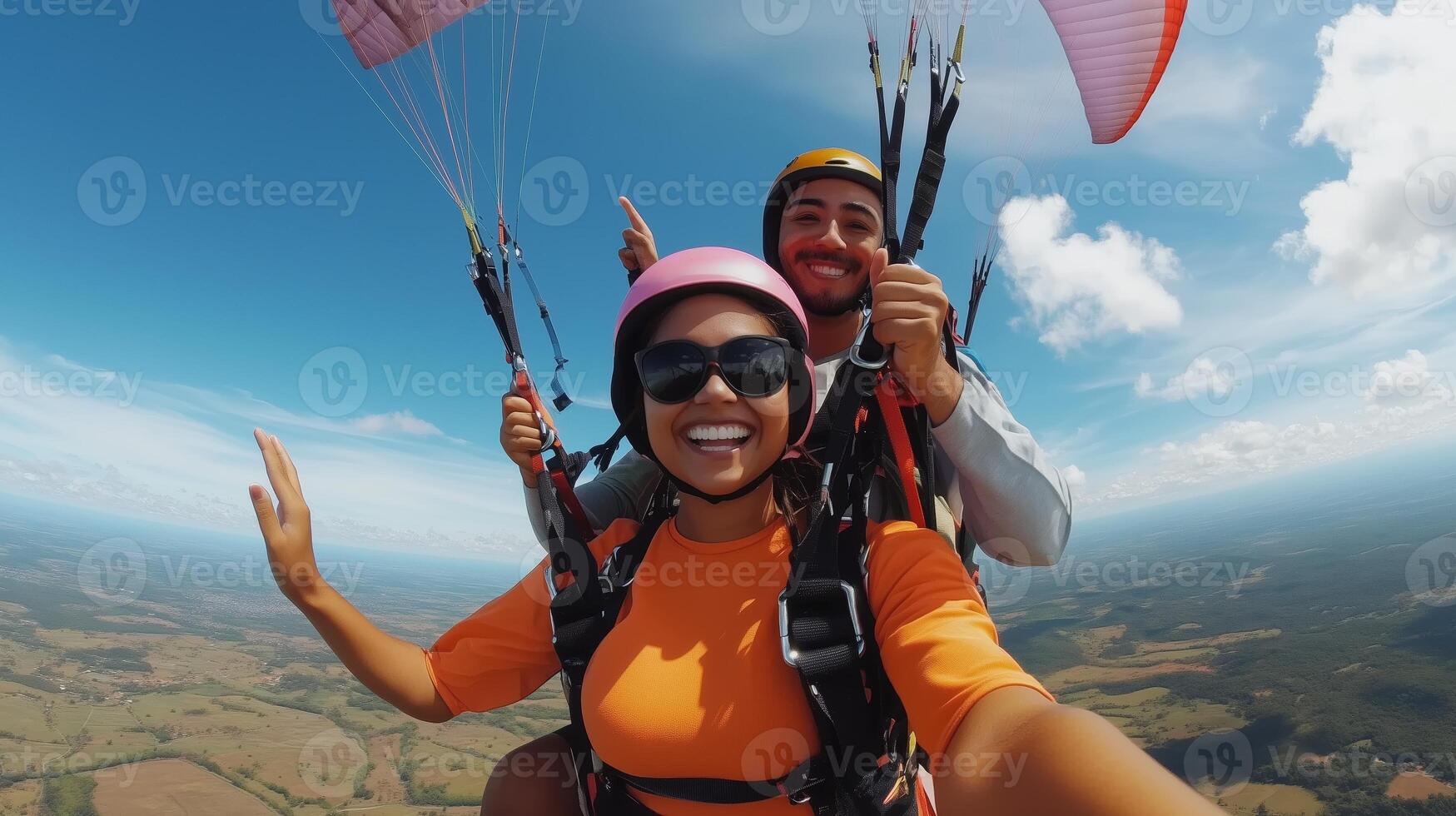 People enjoying a thrilling tandem paragliding experience over picturesque landscapes on a sunny day photo