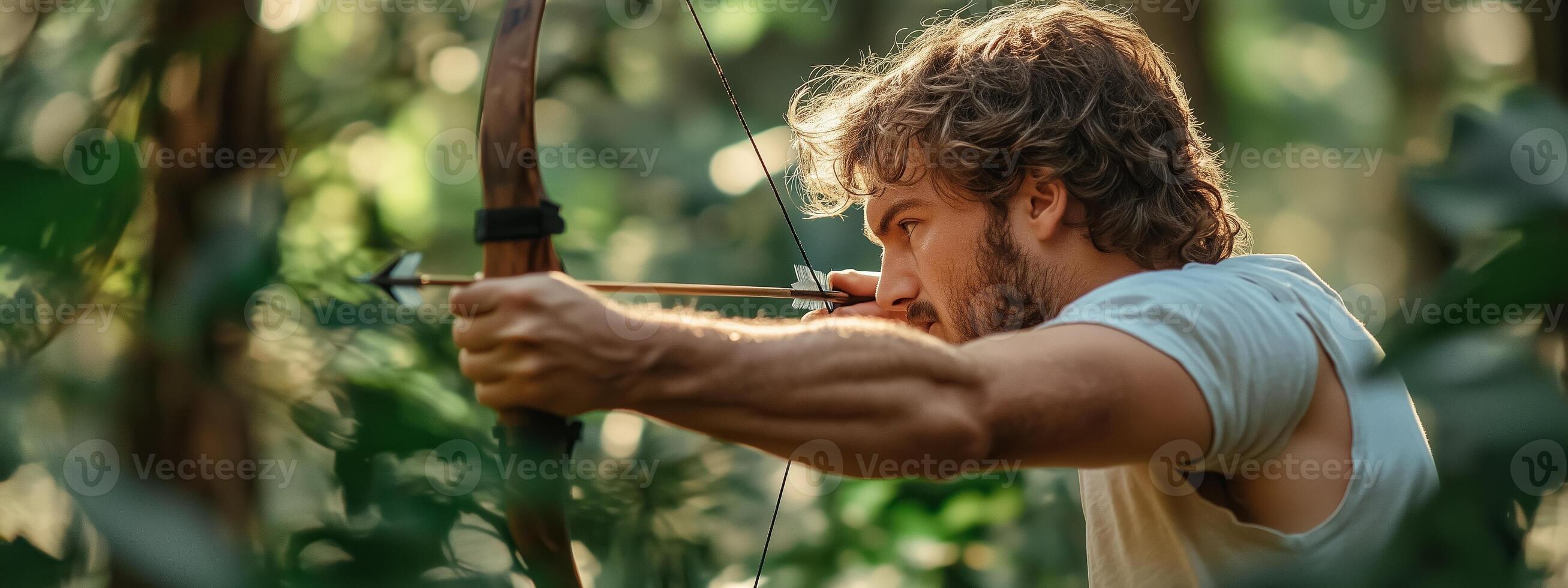 Archer aiming at a target in a lush forest during early morning light, showcasing focus and skill with traditional bow and arrow photo