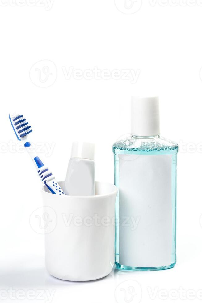 Toothbrushes in glass on table on light background photo