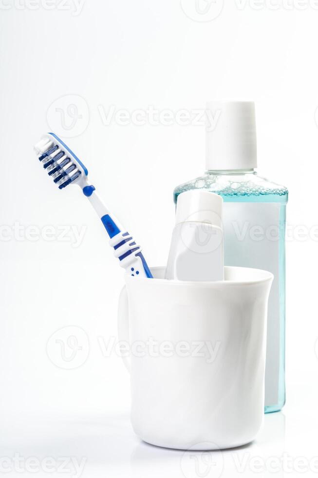 Toothbrushes in glass on table on light background photo