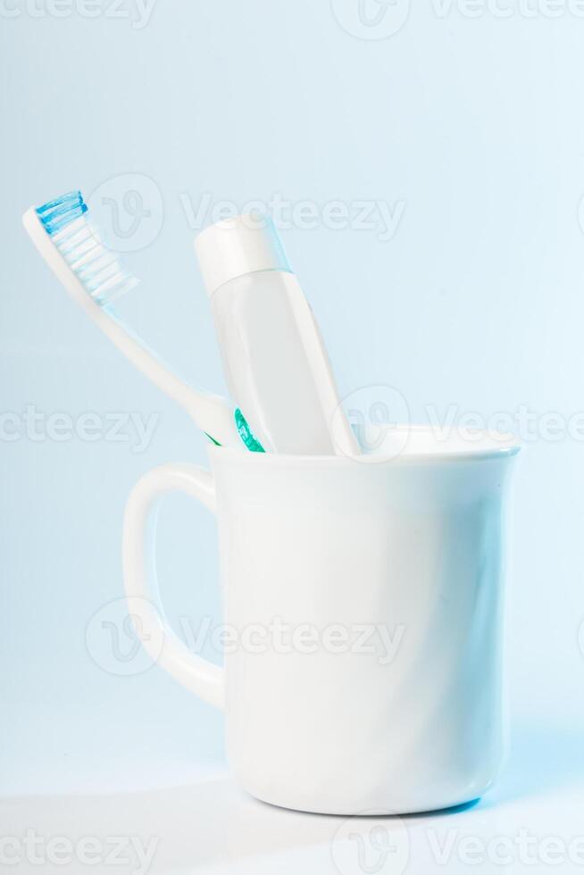 Toothbrushes in glass on table on light background photo