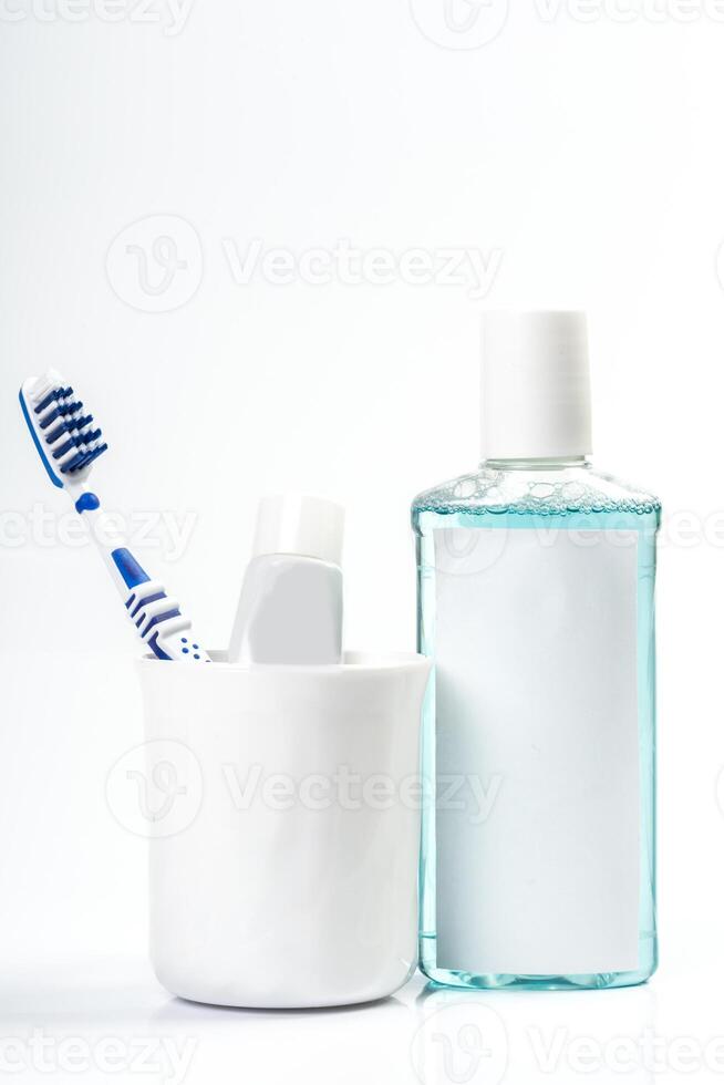 Toothbrushes in glass on table on light background photo