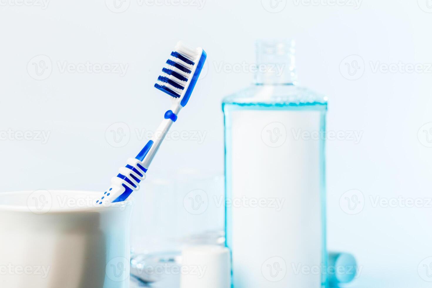 Toothbrushes in glass on table on light background photo