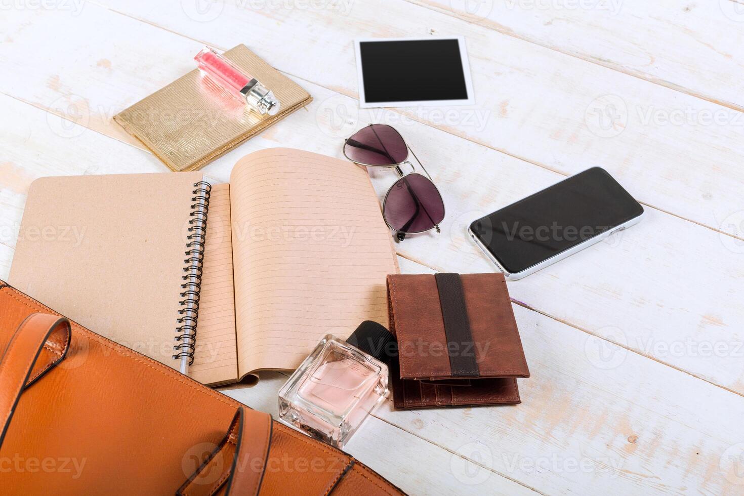 View on women bag stuff on wooden background photo