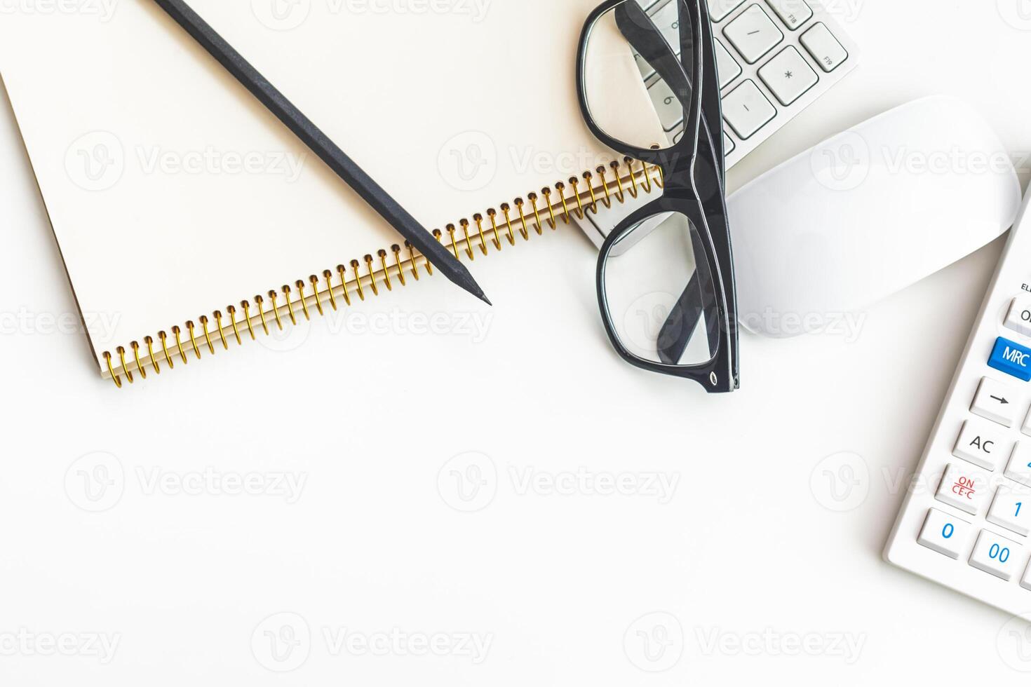 Office desk table with computer keyboard, supplies, calculator, pen, glasses photo