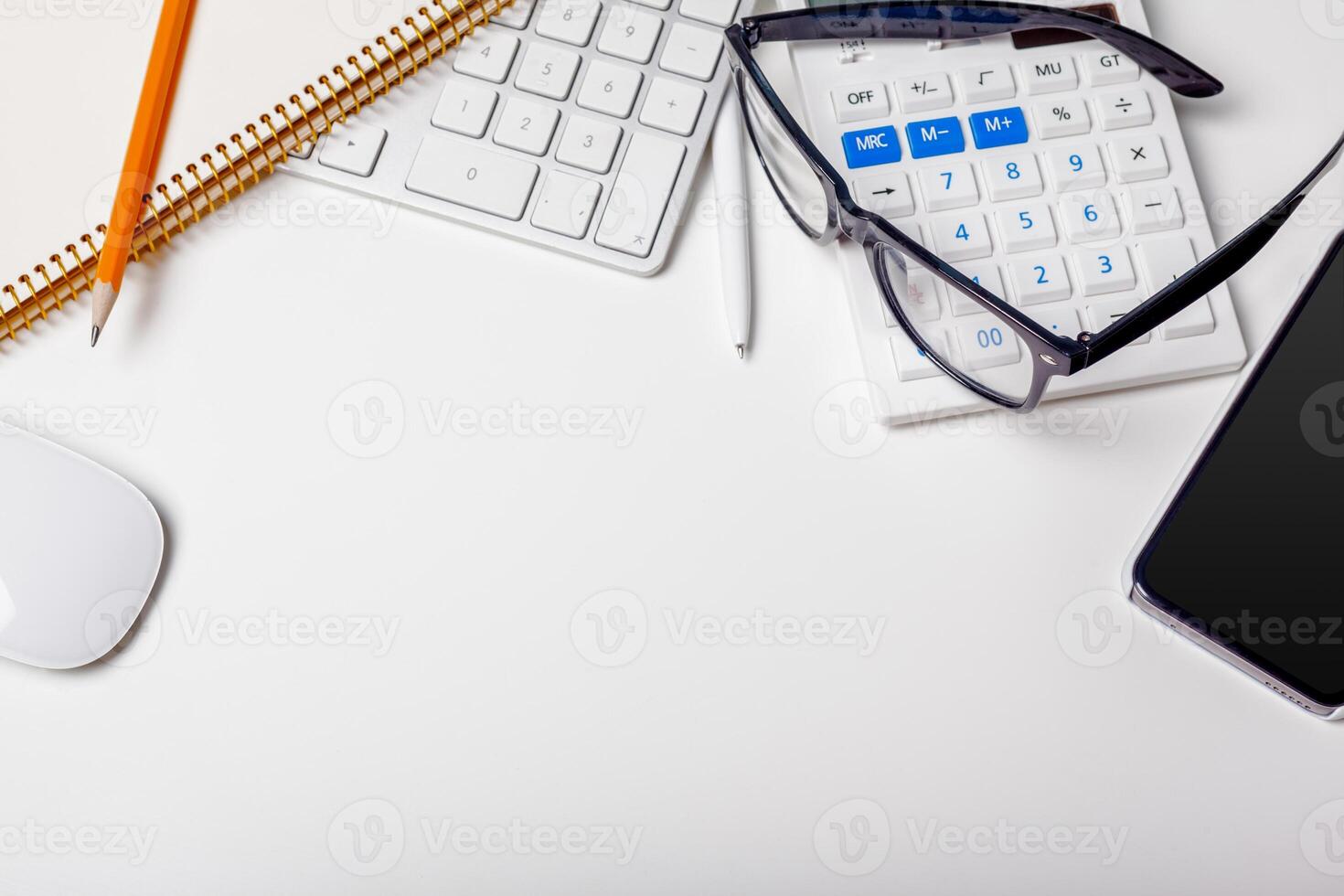 Office desk table with computer keyboard, supplies, calculator, pen, glasses photo