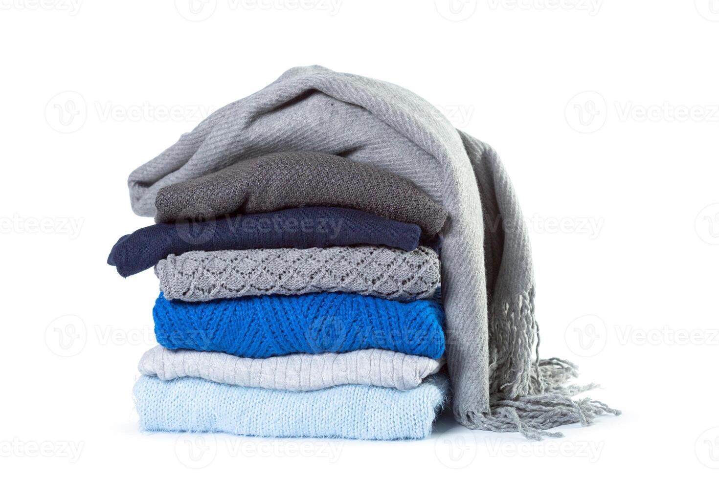 Stack of various sweaters isolated on white background photo