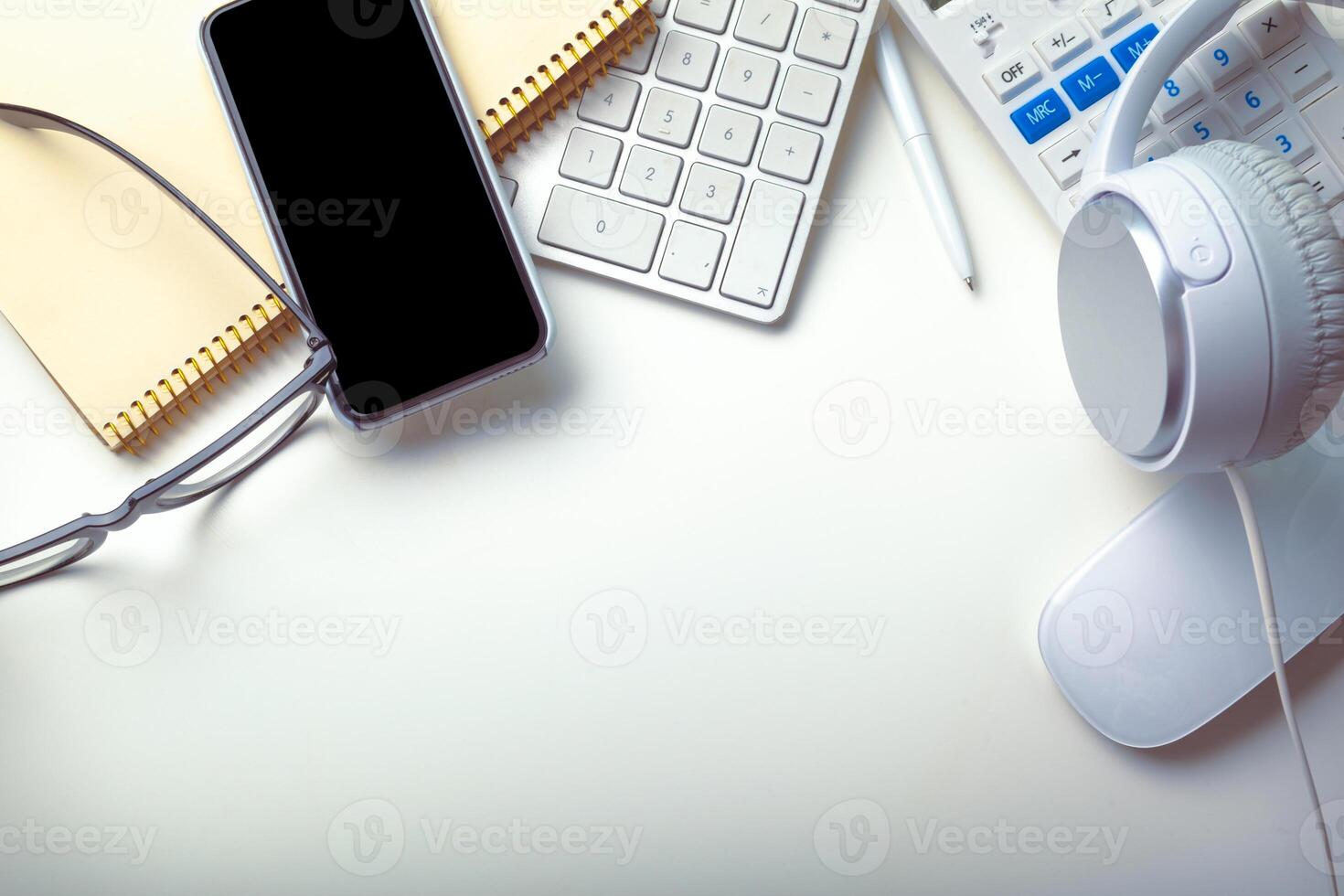 Office desk table with computer keyboard, supplies, calculator, pen, glasses photo