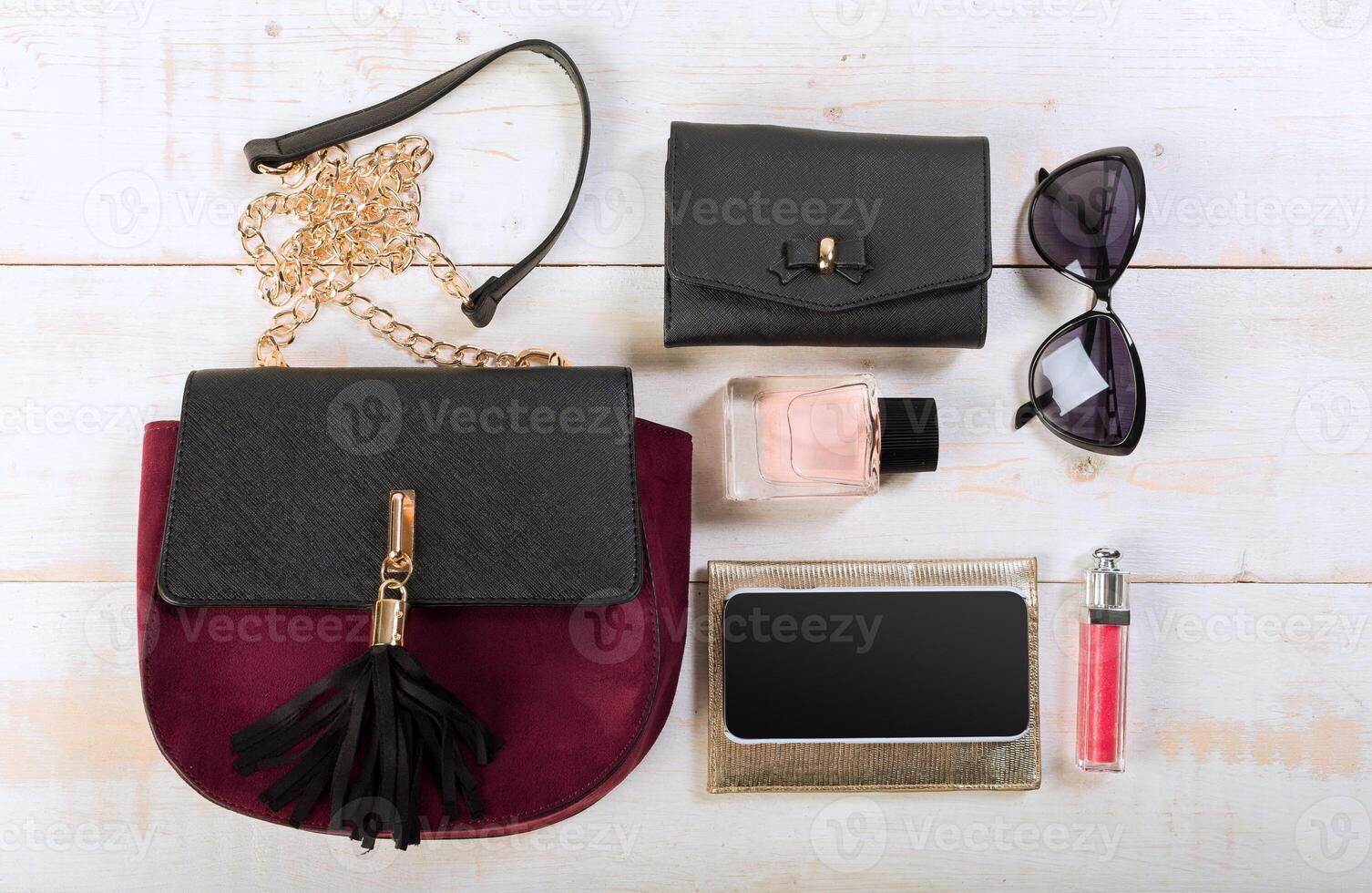 View on women bag stuff on wooden background photo