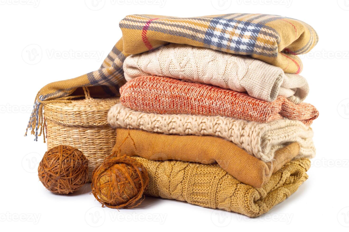 Stack of various sweaters isolated on white background photo