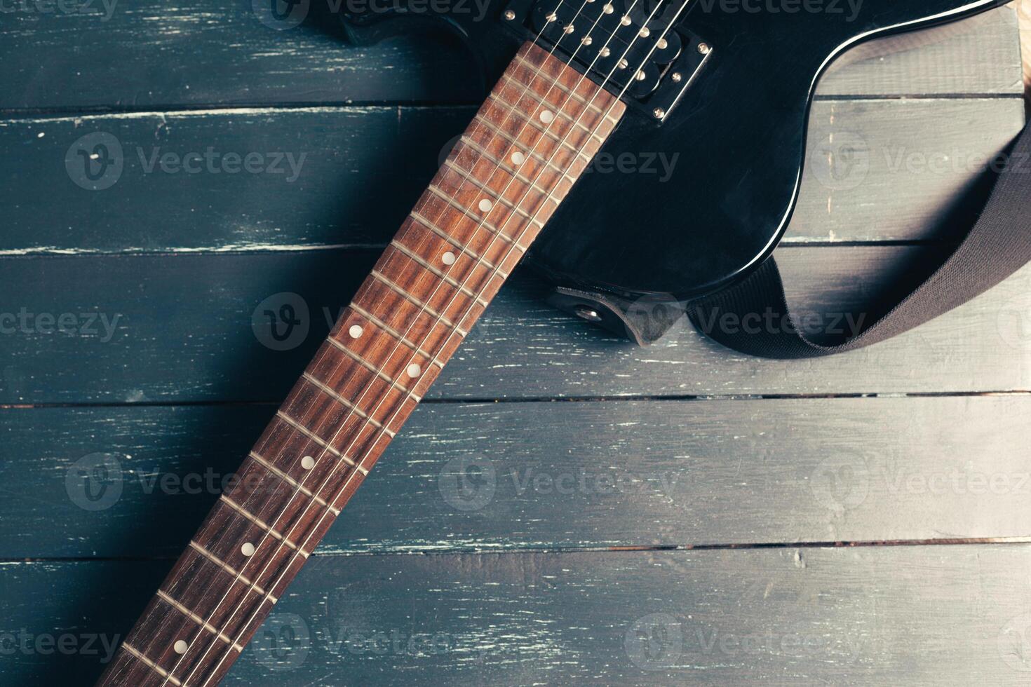 Electric guitar body and neck detail on wooden background photo