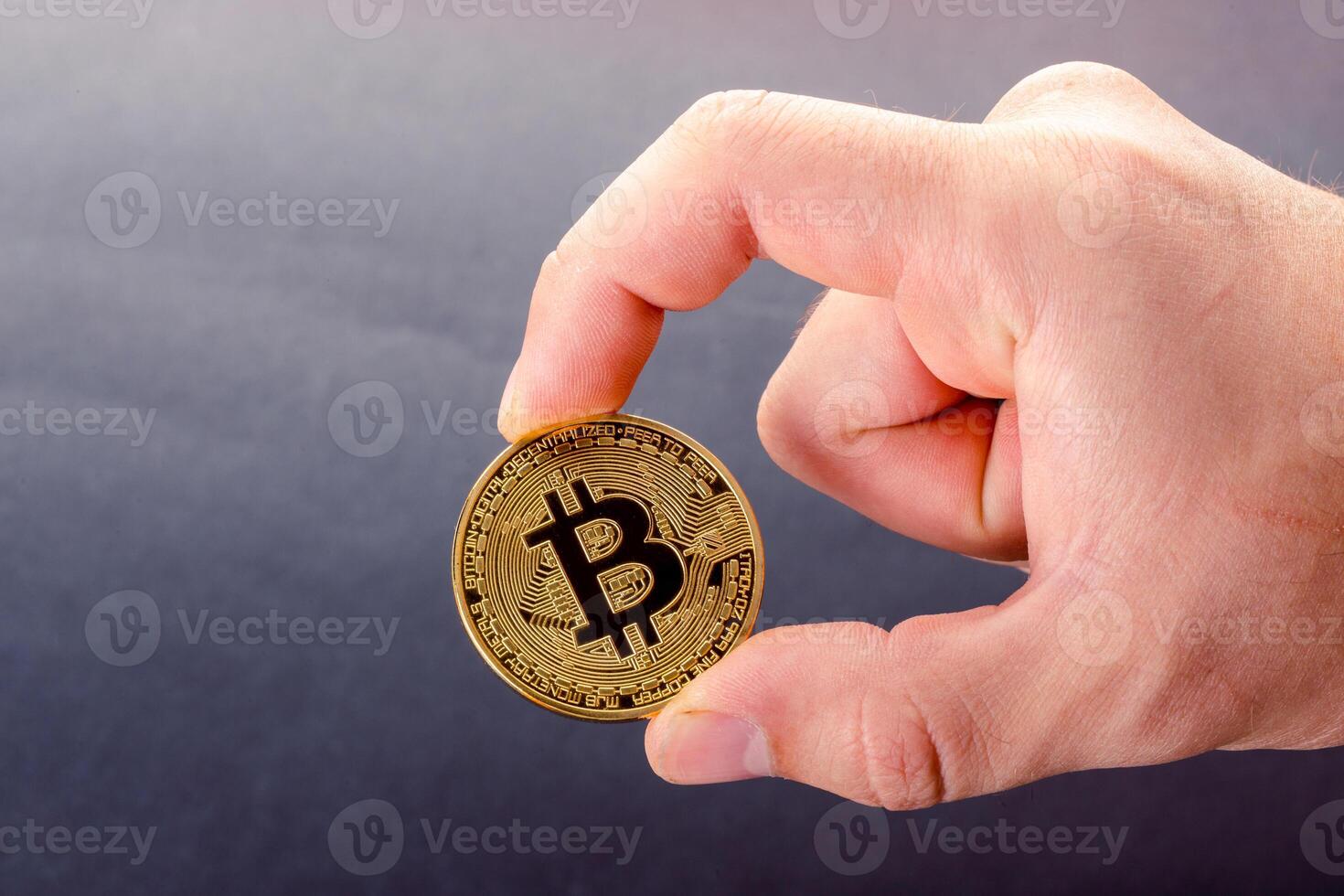 Golden Bitcoin in a man's hand photo