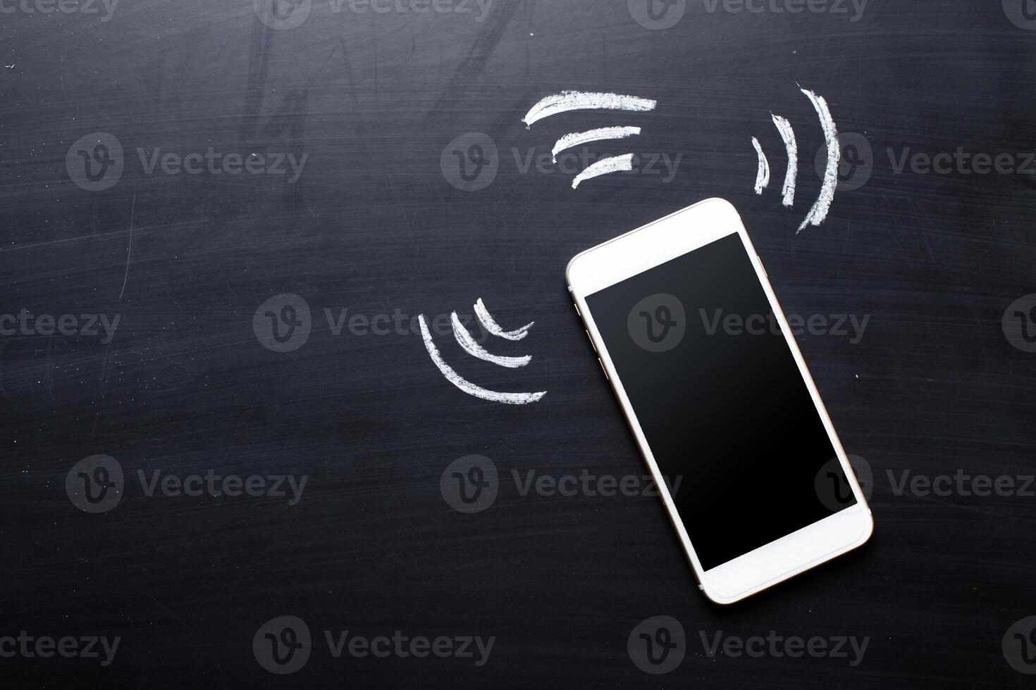 Smartphone on blackboard background photo