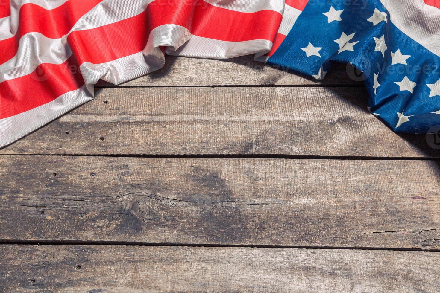 An American Flag Lying on an aged, weathered rustic wooden background photo