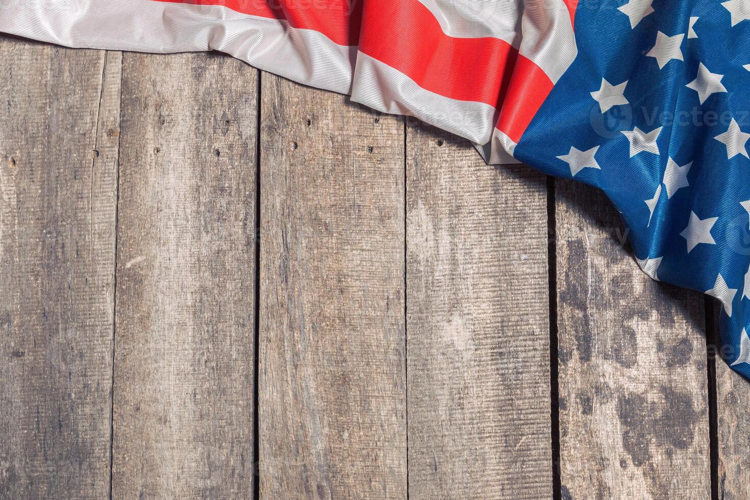 An American Flag Lying on an aged, weathered rustic wooden background photo